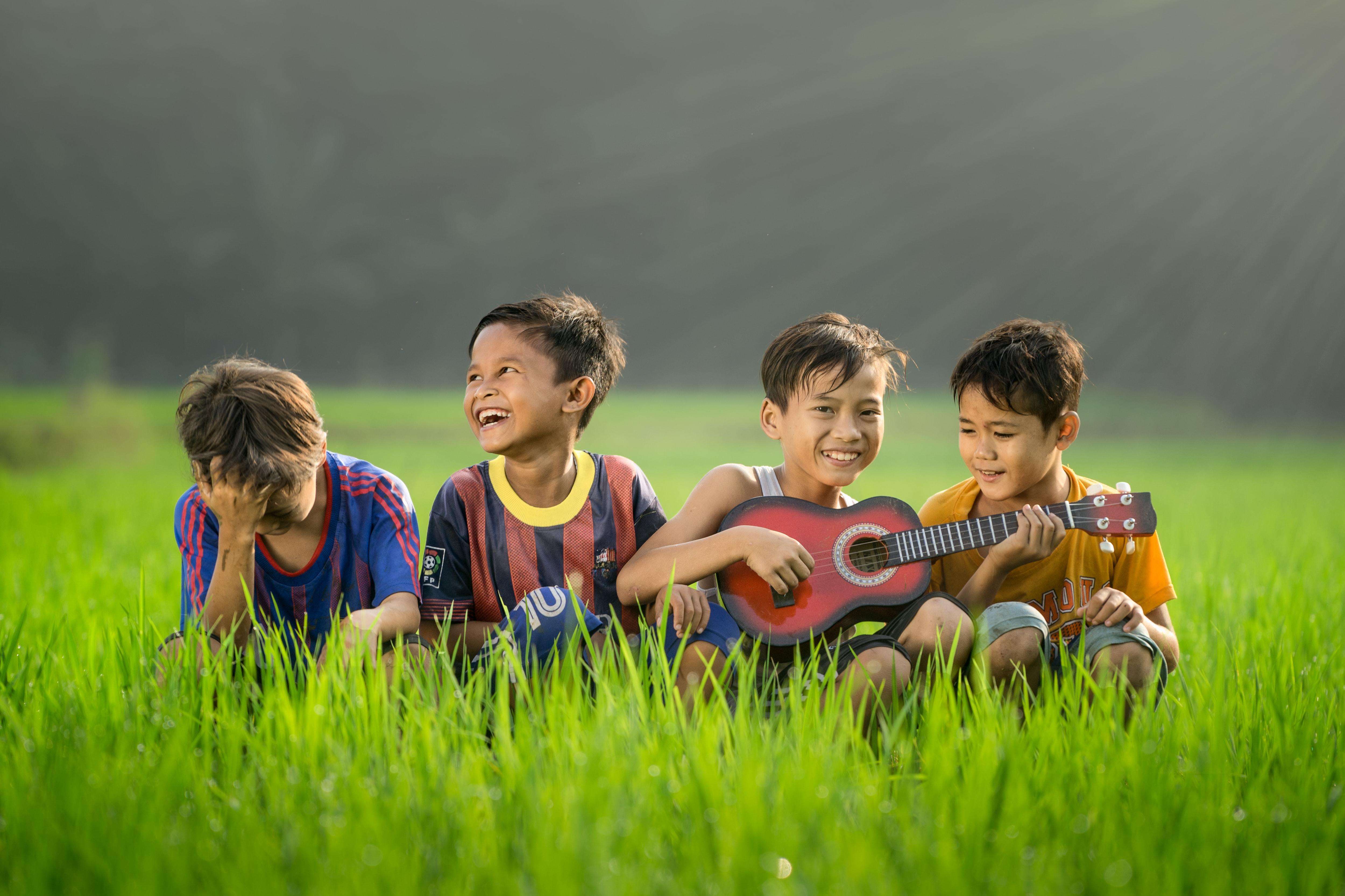 ni&ntilde;os jugando con un instrumento en el c&eacute;sped